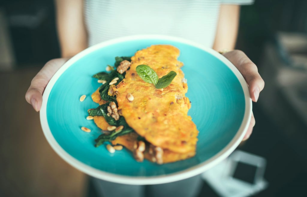 A spinach omelette on a blue plate.