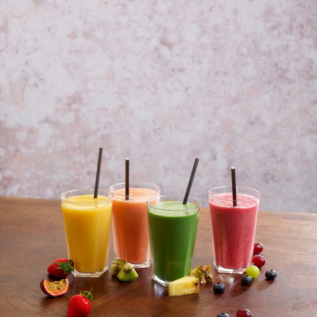 Fruit smoothies with straws in glasses.