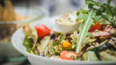 Close up of a salad in a bowl with lettuce and tomatoes.