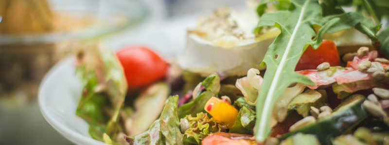 Close up of a salad in a bowl with lettuce and tomatoes.