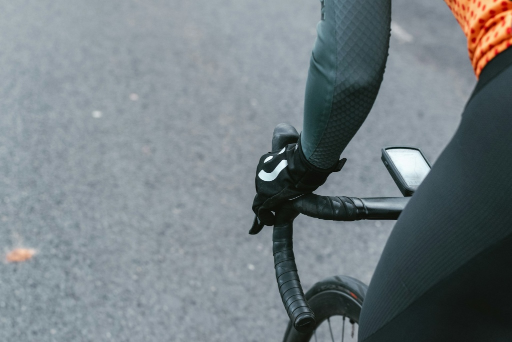 Close-up of a gloved hand on a bike's handlebar.