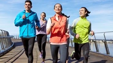 A group of people running together outside and looking happy