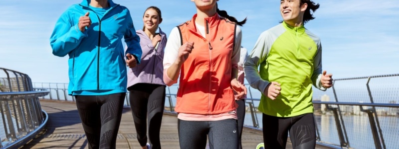 A group of people running together outside and looking happy