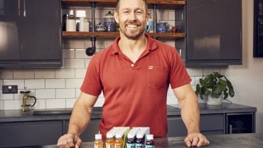 Jonny Wilkinson wearing a red polo shirt smiling at the camera