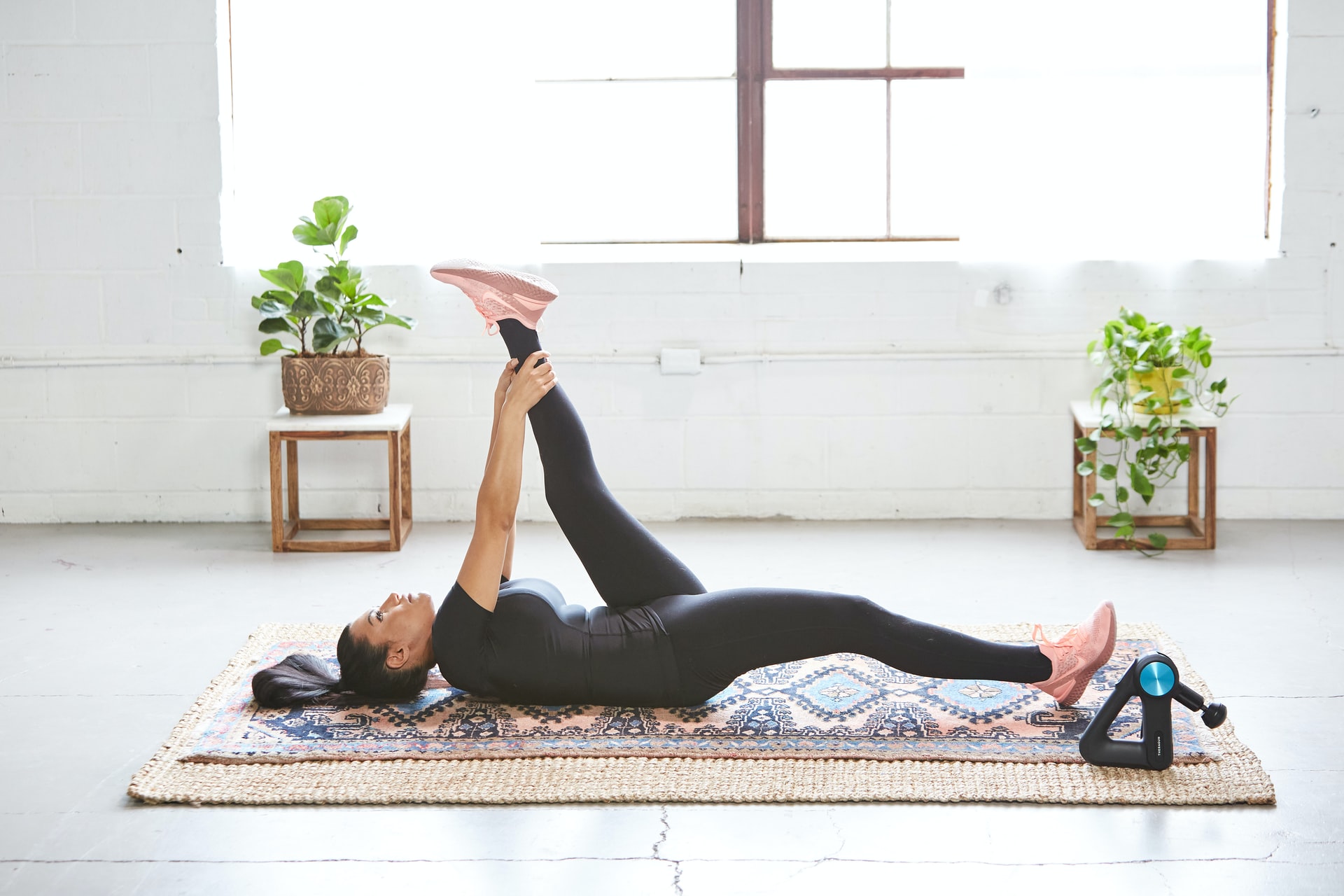 A woman wearing exercise clothing stretching on a yoga mat