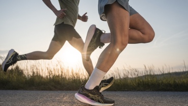 Close up of two runners' legs while they run outside, perhaps racing each other