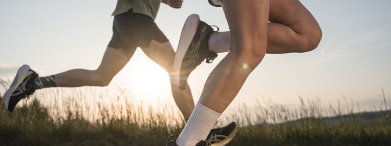 Close up of two runners' legs while they run outside, perhaps racing each other