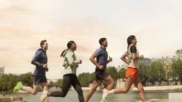 Four people running outdoors.