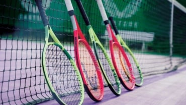 Tennis racquets leaning against a net