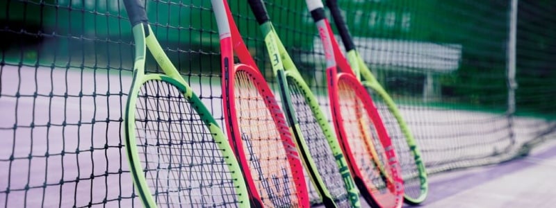 Tennis racquets leaning against a net