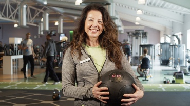 Female-personal-trainer-holding-medicine-ball