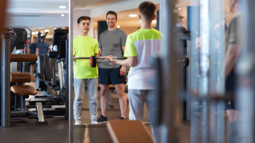 teenager-lifting-weights-in-gym-with-coach