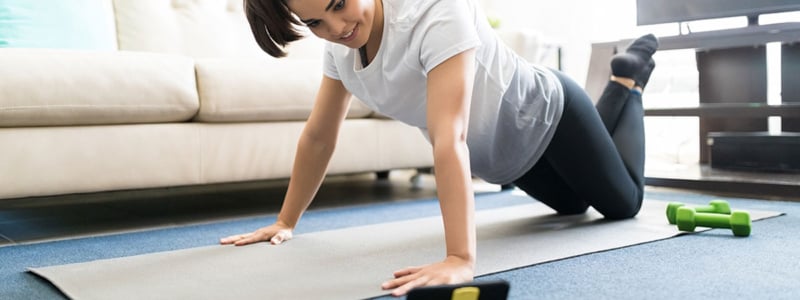 woman-exercising-at-home-with-phone