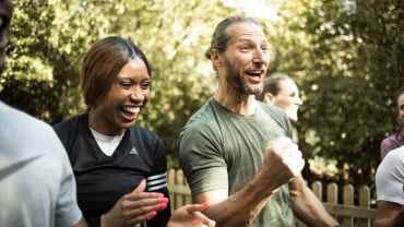 A man and a woman outdoors laughing together