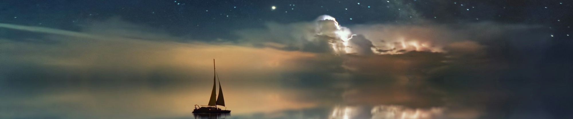 A sailing boat on a calm sea in the night with stars and clouds in the sky.