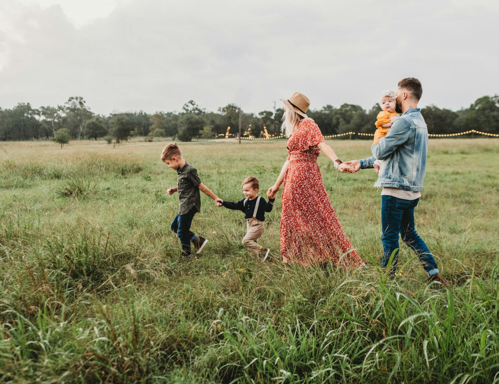 A family walking hand-in-hand across a field.