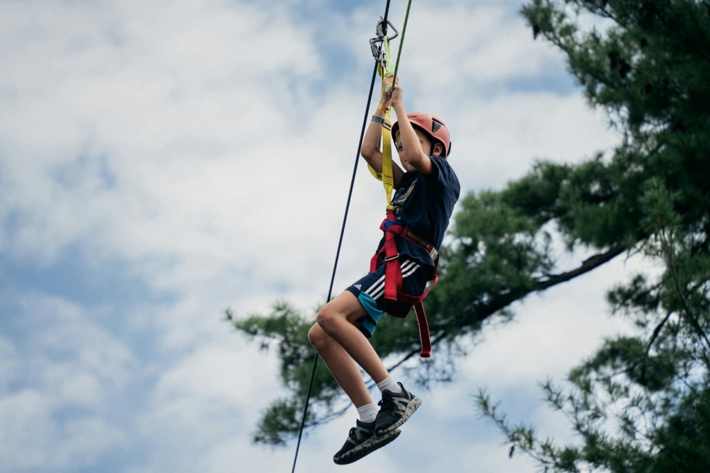 A child mid-air on a zip line.