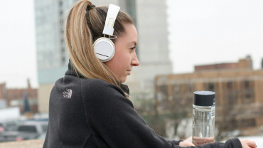 A woman in a running top wearing a pair of headphones.