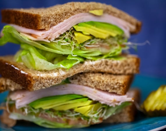 Brown bread sandwich with ham and avocado.