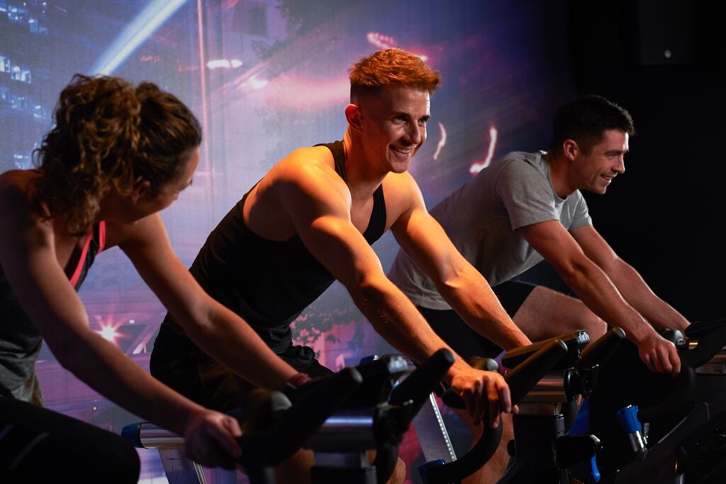 People chatting in a group cycling class.