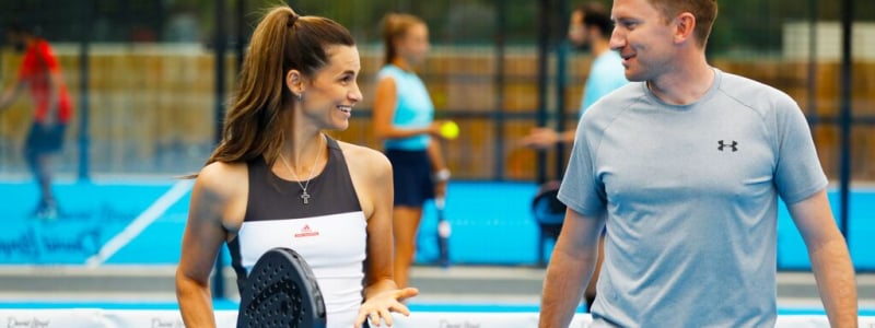 A woman and a man chatting on a Padel court.