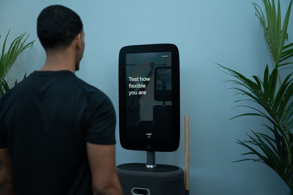 A man standing in front of a David Lloyd Clubs AI-powered Body Hub machine.