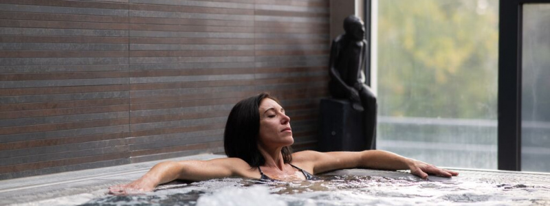 A woman relaxing in an indoor spa pool.